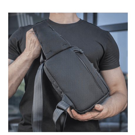 Person bærer M-Tac Sling pistolveske Elite Hex, komfortabel og holdbar veske med justerbar skulderrem og slitesterkt materiale.