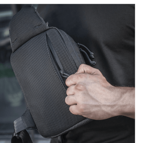 M-Tac Sling pistolveske Elite Hex i bruk med justerbar skulderrem og romslige rom, laget av slitesterkt Cordura-materiale.