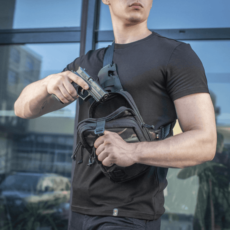 Mann med M-Tac Sling pistolveske Elite Hex, som viser skjult våpenbruk. Komfortabel og slitesterk veske for diskret transport.