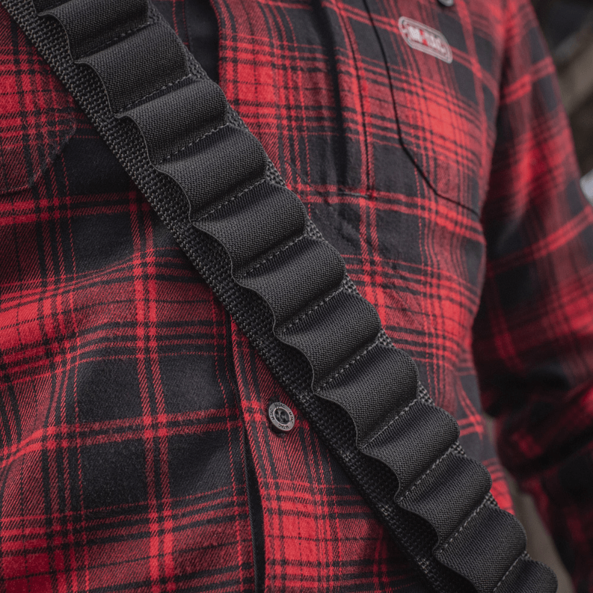 M-Tac Bandolier Elite patronbåndelier til jagt med dobbelte stropper, vist på en person i rødternet skjorte. Kapacitet: 55 skaller.