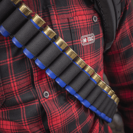 M-Tac Bandolier Elite patronbandolier for jakt og skytesport med kapasitet 55 skudd, båret over rødrutet skjorte.