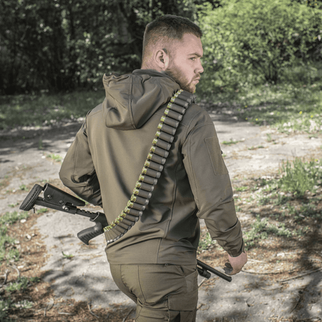Jeger iført M-Tac Bandolier Elite med ammunisjon i skogmiljø.