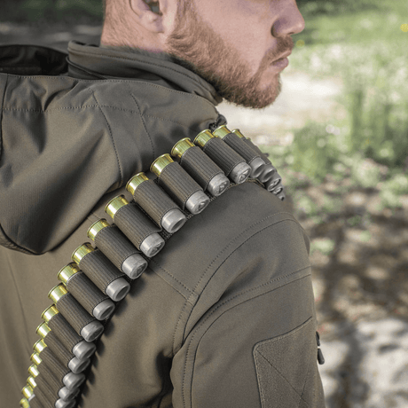 M-Tac Bandolier Elite bæres av person, viser patronbelte for jakt og skytesport. Praktisk design, kapasitet 55 skudd.
