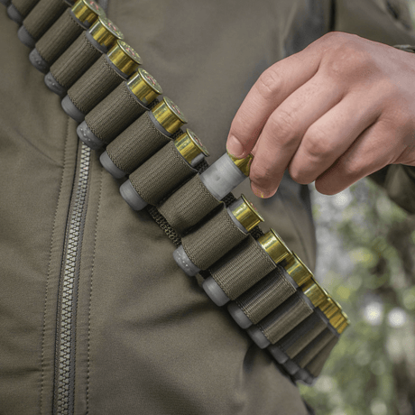 Person iført M-Tac Bandolier Elite fylt med ammunisjon for jakt og skytesport.