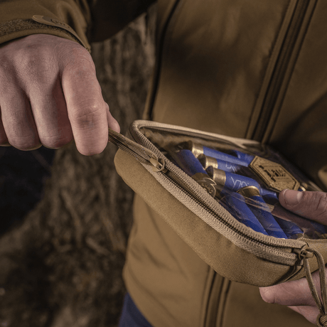 Person åpner M-Tac Utility Organizer Slim Elite i Cordura 500D med synlige gjenstander gjennom PVC-folie.