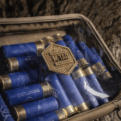 M-Tac Utility Organizer Slim Elite med gjennomsiktig forvegg, oppbevarer blå patronhylstre sikkert og organisert i naturmiljø.