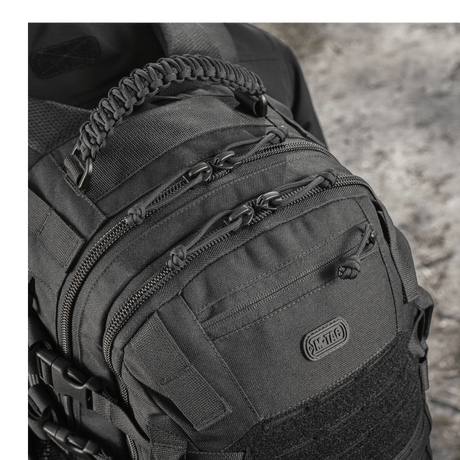 M-Tac Mission Pack Elite ryggsekk med slitesterkt Cordura 1000D-materiale og MOLLE LASER CUT-system detalj, sett i nærbilde.
