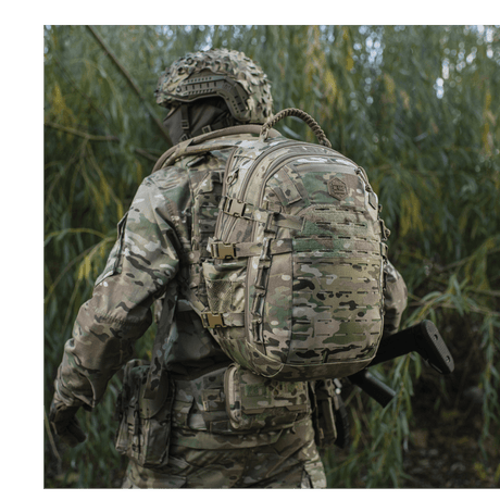 M-Tac Mission Pack Elite ryggsekk i camouflage med MOLLE LASER CUT-system i skogområde.