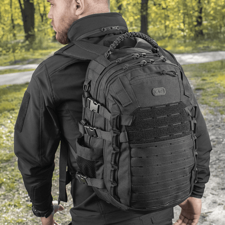 M-Tac Mission Pack Elite ryggsekk med slitesterkt Cordura 1000D og MOLLE LASER CUT-system i skogmiljø.