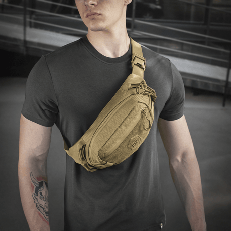 Person med M‑Tac belteveske Elite Hex i stilfullt design, ideell for hverdag eller taktisk bruk. Laget i Cordura med kvalitetslynlåser.