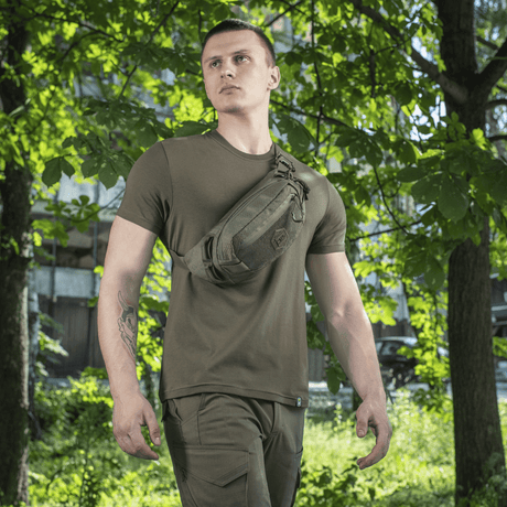 M-Tac belteveske Elite Hex båret av person i naturmiljø. Veske i Cordura 500D med YKK-lynlåser og Woojin-spenner.