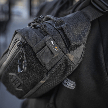M‑Tac belteveske Elite Hex vises båret av en person, laget i Cordura med YKK-glidelåser, ideell for daglig eller taktisk bruk.
