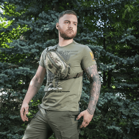 Mann iført M‑Tac belteveske Elite Hex i et utendørs miljø, ideell for hverdagsbruk og taktiske formål, laget av holdbart Cordura.