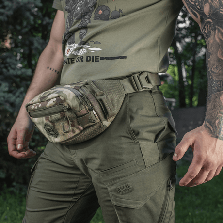 M-Tac belteveske Elite Hex i kamuflasje, slitesterkt Cordura-materiale, på person i grønt friluftsantrekk.
