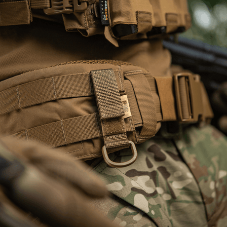M-Tac feste med D-ring for MOLLE-system på taktisk utstyr, viser sikker opphenging og justerbar Velcro-lukking.
