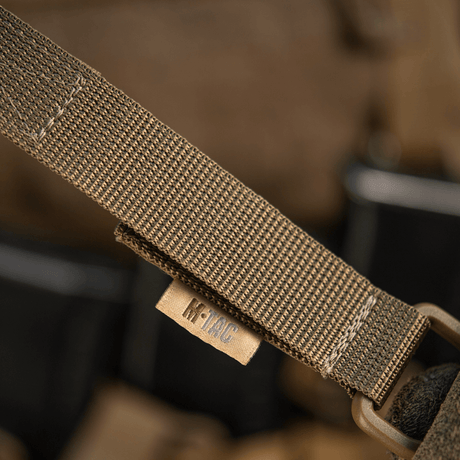 M-Tac feste med D-ring for MOLLE-systemer med Velcro-lukking, perfekt for taktisk bruk på ryggsekker og vester.