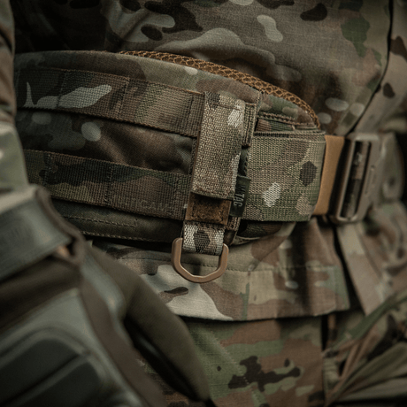M-Tac feste med D-ring på taktisk MOLLE-belte i kamuflasjemønster, ideell for montering av utstyr med Velcro-lukking.