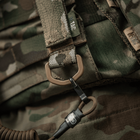 M-Tac feste med D-ring for MOLLE-utstyr på kamuflasjevester.