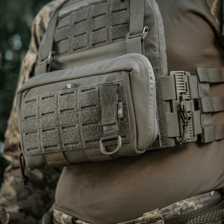 M-Tac feste med D-ring montert på taktisk vest med MOLLE-system for sikker opphenging av utstyr via Velcro-lukking.