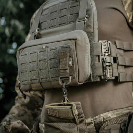 M-Tac feste med D-ring montert på taktisk vest med MOLLE-system og Velcro-lukking.