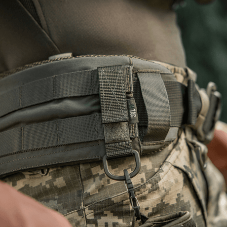 M-Tac feste med D-ring på taktisk belte med MOLLE-system og Velcro for sikker opphengning og justerbar passform, ideell for utendørs bruk.