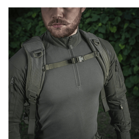 Mann iført M-Tac Mission Rygsæk Elite Hex laget av Cordura 1000D med ergonomisk design og MOLLE LASER CUT-system i skogmiljø.