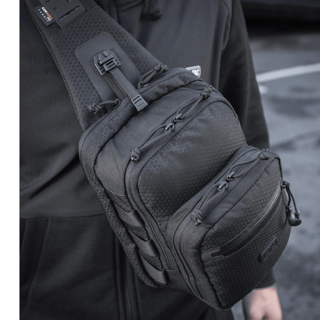 Mann iført M-Tac Cross Taske Slim Elite Hex i sort på skulderen.