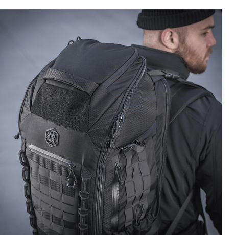 M-Tac Rygsæk Large Elite Hex Gen. IV på ryggen av en person i svarte klær, viser holdbarhet og stilfullt design i Cordura-materiale.