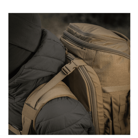 Person med M-Tac Ryggsekk Large Elite Hex Gen. IV, ergonomisk og funksjonell, designet for å bære våpen, laget av slitesterk Cordura.