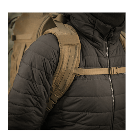 Mann iført M-Tac Ryggsekk Large Elite Hex Gen. IV med polstret skulderreim, designet for komfort og funksjonalitet under utendørs bruk.