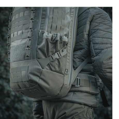 M-Tac Ryggsekk Large Elite Hex Gen. IV bæres av en person, viser sekkens stilfulle utseende og holdbare materialer som Cordura 500D og Hex 1000.