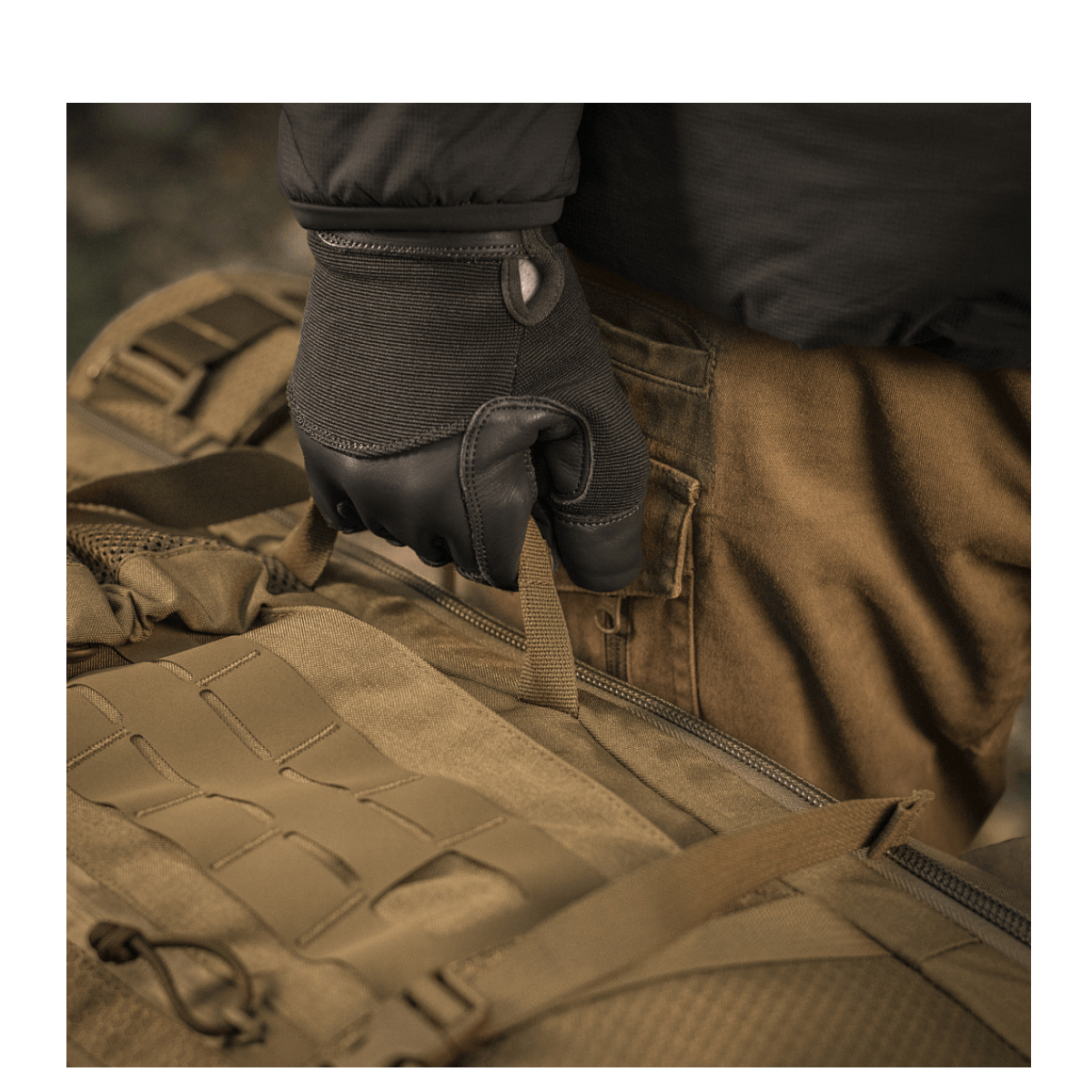 Person holder M-Tac Rygsæk Large Elite Hex Gen. IV, fremstillet af holdbare Cordura-materialer. Ergonomisk design med stilfuldt look.
