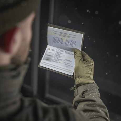 Person holder et pass beskyttet av M‑Tac Pascover i vinterklær.