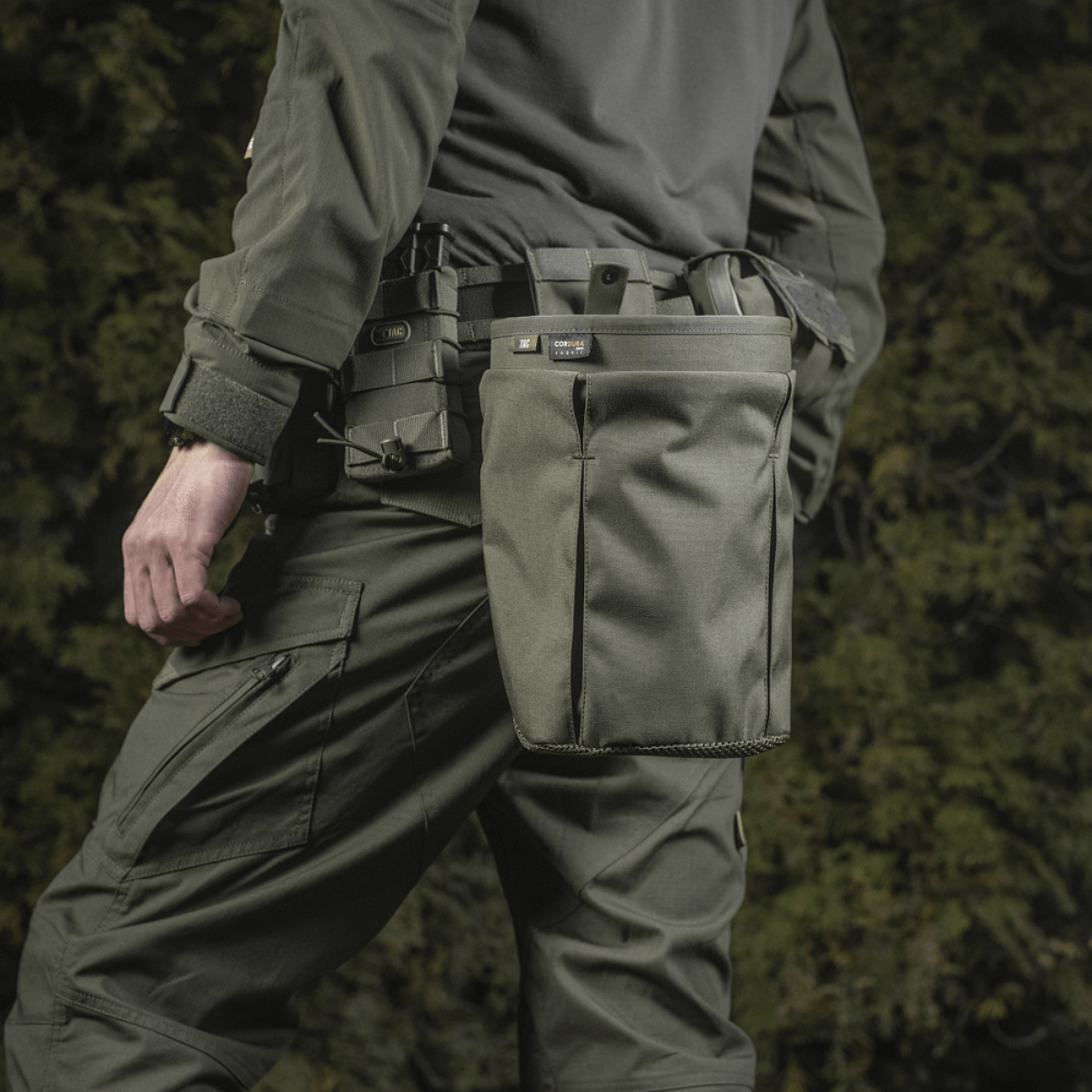 Person wearing M‑Tac Magasinsæk Dump Pouch Lite Elite attached to MOLLE system, demonstrating tactical use.