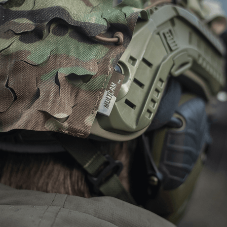 M-Tac Vilha Hjelmcover FAST med multicam-mønster, designet for kamuflasje og beskyttelse i ujevnt terreng; sett tett på.