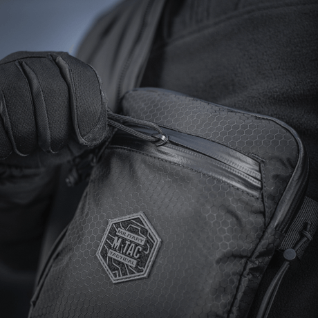 M‑Tac Pocket Bag Elite HEX i bruk, kompakt veske med slitesterkt materiale og holdbar glidelås, egnet for oppbevaring av EDC-utstyr og verktøy.