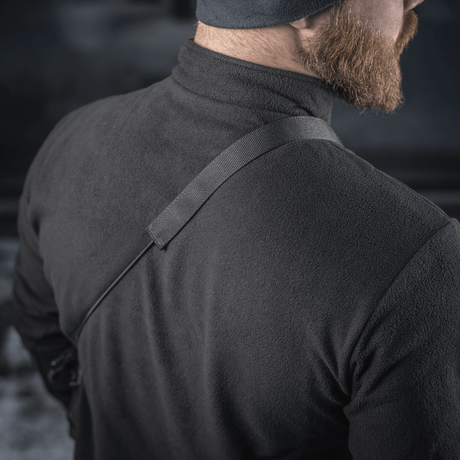 M-Tac Pocket Bag Elite HEX bæres over skulderen på en mann i svart jakke, viser remmens styrke og bærekomfort.