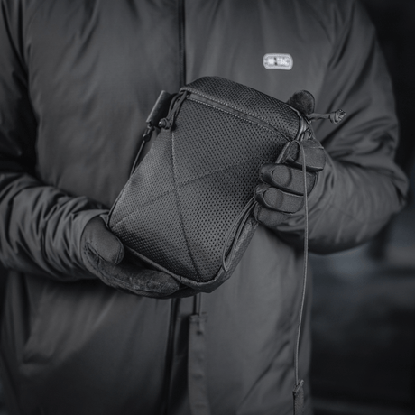 M‑Tac Pocket Bag Elite HEX i svart, holdt av en person med hansker. Kompakt veske perfekt for oppbevaring av diverse småting.