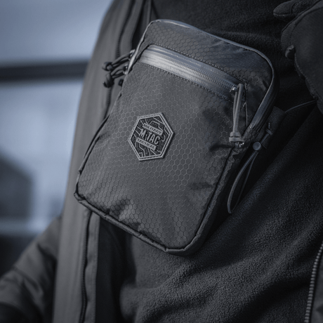 En person bærer en kompakt, robust M‑Tac Pocket Bag Elite HEX med slitesterke YKK-glidelåser, egnet for hverdagens oppbevaringsbehov.