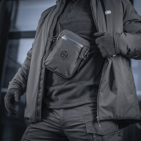M-Tac Pocket Bag Elite HEX i bruk som praktisk kompakt veske for oppbevaring, laget i slitesterkt materiale med holdbare YKK-glidelåser, egnet for daglig bruk.