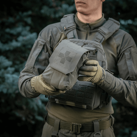 Person holder M‑Tac Medic Pouch Vertical Large Elite i slitesterkt Cordura, ideell for førstehjelpsutstyr og rask tilgang.