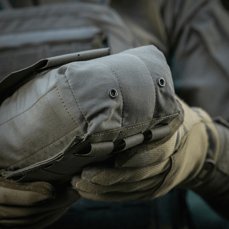 M‑Tac Medic Pouch Vertical Large Elite i slitesterkt Cordura 500D, sikker oppbevaring av medisinsk utstyr, holdt av person med hansker.