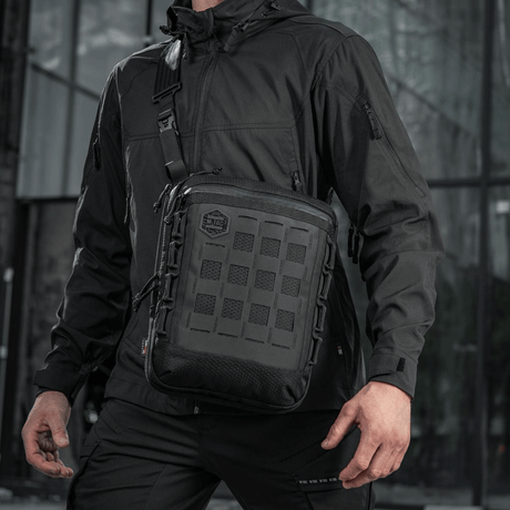 M-Tac Tablet Bag Laser Cut Hex båret av en mann i svart jakke, robust og praktisk veske for EDC og skjult bæring.