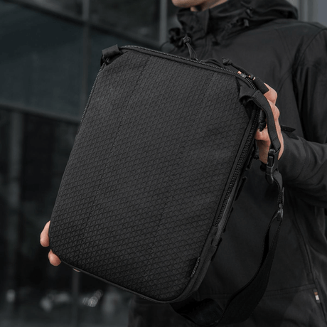M-Tac Tablet Bag Laser Cut Hex, praktisk veske i Cordura med Laser Cut MOLLE og rom for skjult våpen, vist i hånd.