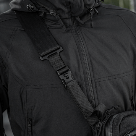 Nærbilde av svart M-Tac Tablet Bag Laser Cut Hex skulderveske på person, laget i holdbart Cordura-materiale med justerbar rem.