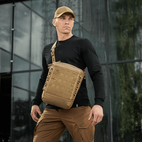 Mann bærer M-Tac Tablet Bag Laser Cut Hex-veske i Cordura-materiale med Laser Cut MOLLE, ideell for EDC, dokumenter og nettbrett.