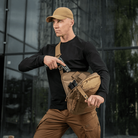 M-Tac Tablet Bag Laser Cut Hex i bruk for rask tilgang og skjult oppbevaring, båret av en person i utendørs miljø.