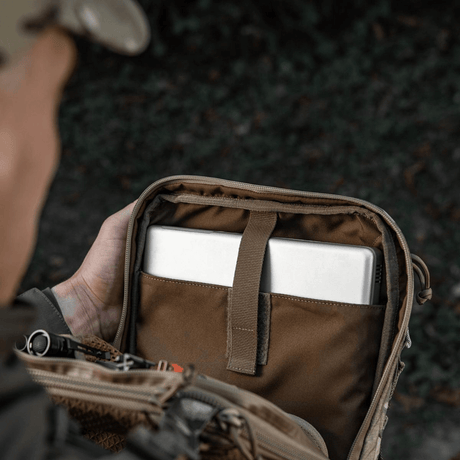 Person åpner M-Tac Tablet Bag Laser Cut Hex med innhold som nettbrett og dokumenter.