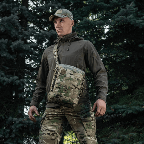 Mann bærer M-Tac Tablet Bag Laser Cut Hex i skogmiljø, camo-tilbehør med laserutskåret MOLLE for EDC, dokumenter og våpen.