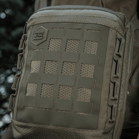 M-Tac Tablet Bag Laser Cut Hex i Cordura-stoff med Laser Cut MOLLE-design, ideell for EDC, dokumenter og nettbrett, i naturlig miljø.
